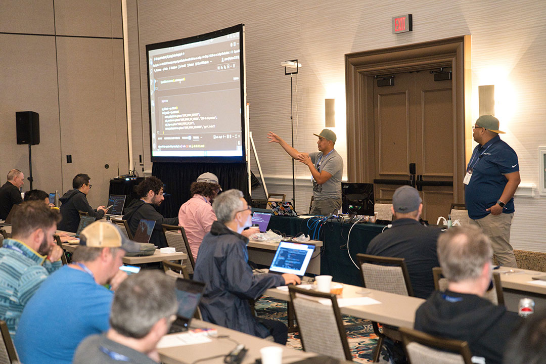 At Black Hat USA 2025, three rows of students sit in front of an instructor, who is standing in front of a presentation. The presentation screen shows a technical training slide.