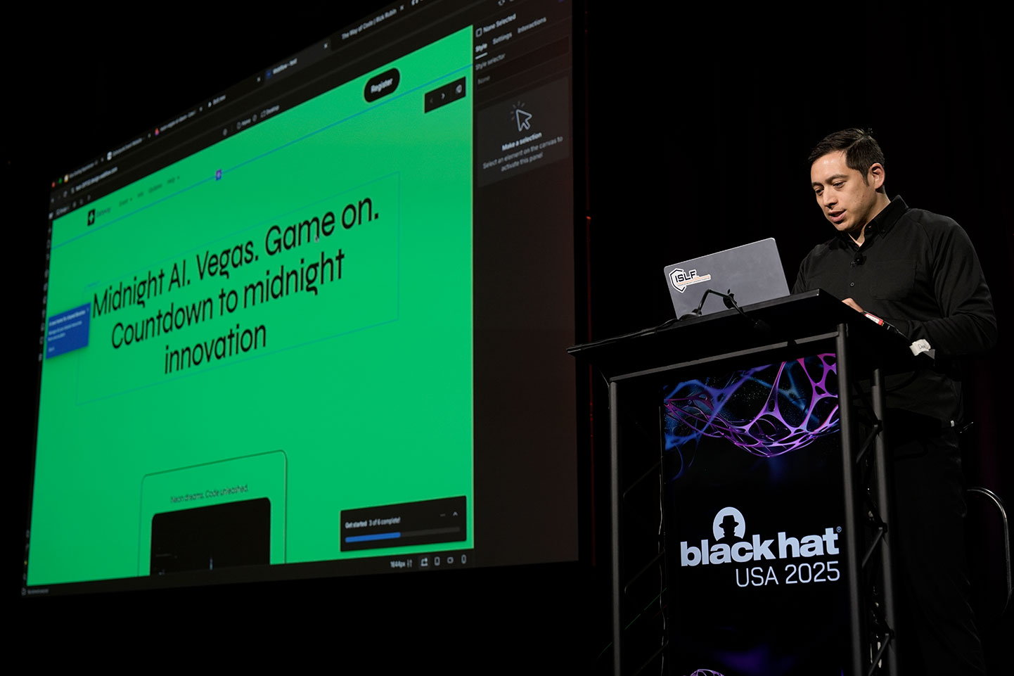 At Black Hat USA 2025, a speaker stands at a podium with an open laptop in front of him. The screen behind him reads: "Midnight AI. Vegas. Game on. Countdown to midnight innovation."